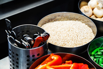 Rice in a metal bowl. Preparing to cook a dish of rice and vegetables. Selective focus. Close-up
