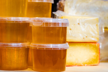 Honey in plastic jars in a farm shop window. Close-up