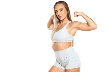 Fototapeta na wymiar young sports woman with long hair in a shorts and top showing biceps on a white background
