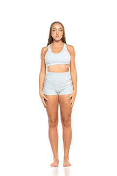 young barefoot sports woman with long hair in a shorts and top on a white background