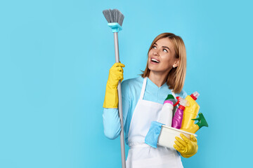 woman in gloves holding bucket of detergents and broom