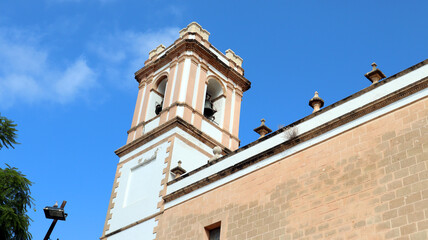 Bell tower of the main cathedral of Denia, Spain, more bells against blue sky, catholic cathedral