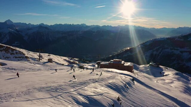 Leukerbad, Switzerland: Aerial time lapse of skiers and snowboarders going downhill on the slope of the Leukerbad ski resort in winter in the Swiss alps in Canton Valais. 