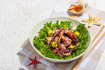 Octopus salad with lettuce, olives and spices in a bowl. Fresh and healthy seafood, marine decor