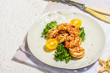 Grilled shrimp salad with lettuce, tomato cherries and spices on a plate. Fresh and healthy seafood