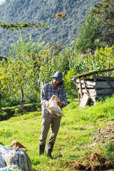 Naklejka premium Caucasian farmer standing with mountains in background.