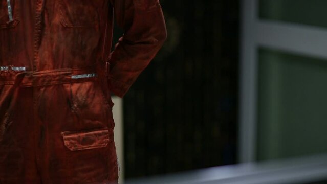 A man wearing dirty orange cloth pulls a hidden knife from behind and slashes down (horror scene in 2 different styles)