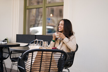 Young smiling african american girl drinking coffee in a cozy cafe. Holidays, lunch time and vacation concept      