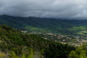 Village in the distance with incredible landscape of mountains full of green colour and a sky...