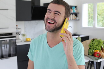 Handsome man calling from his kitchen