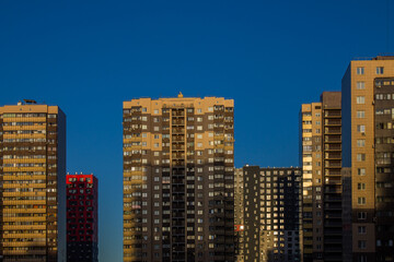 Fototapeta na wymiar Facades of modern multi-storey buildings against a bright blue sky and a space for copying in the city Reutov, Moscow region, Russia