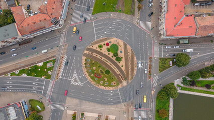 Top view photography of a traffic roundabout in a crouded city. Photo was shot from a drone with camera pointing straight  downwards.