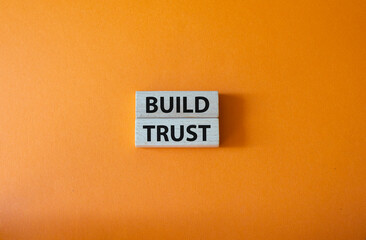 Build trust symbol. Wooden blocks with words Build trust. Beautiful orange background. Business and...