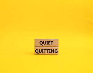 Naklejka premium Quiet quitting symbol. Concept word Quiet quitting on wooden blocks. Beautiful yellow background. Business and Quiet quitting concept. Copy space.