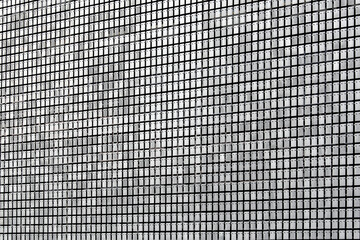 protective screen metal rectangular plates with rivets on the facade of the building with decorative pattern of gray stainless steel sheets, industrial architecture close-up details.