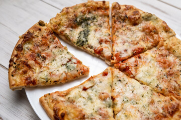 Sliced pizza with blue cheese on a white plate. Pieces of freshly cooked pizza.