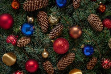 Christmas holiday background with Christmas decorations and fir tree branches with cones. Top view, close up