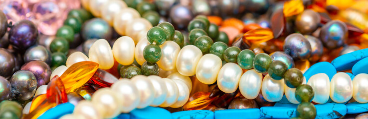 Beads and necklaces made of colored semi precious stones. Background from a variety of beautiful...