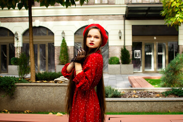 A girl in a red beret walks in the autumn city