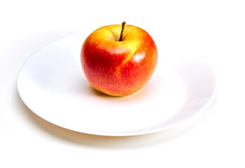Insulated red juicy apple on a white plate on a white background
