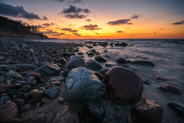 Obraz na płótnie Canvas Wonderful orange sunset on the rocky coast of the sea