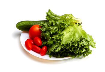 Fresh tomatoes, cucumber and lettuce on a white plate. Isolated.