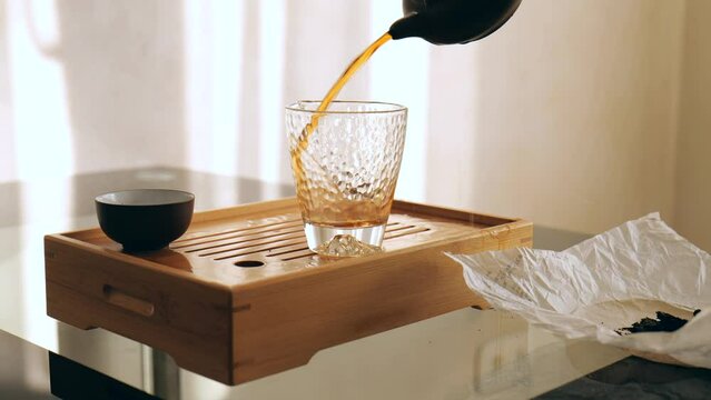 man pouring pu-erh tea into chahay. Chinese tea in a traditional ceremony and pouring tea from a teapot. 4k. slow motion