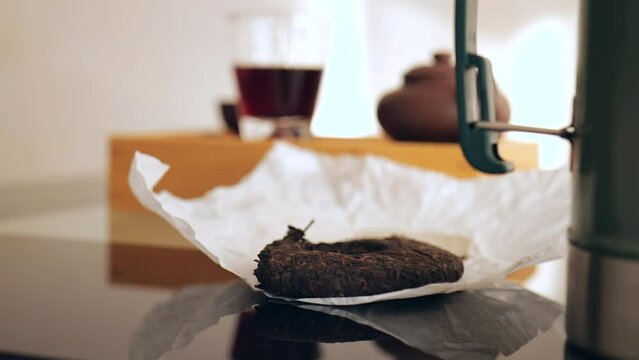 pressed dark pu-erh. blurred tea ceremony background. 4k. slow motion