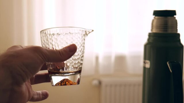 a man holds a glass bowl in his hand for the Chinese tea ceremony. cup of justice. 4k. slow motion
