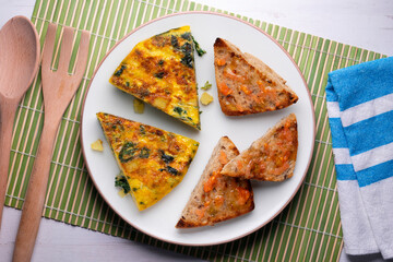 Spanish omelette with potatoes and spinach. Two pieces of bread with tomato. Typical tapas of Barcelona.