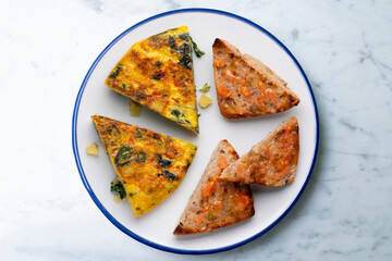 Spanish omelette with potatoes and spinach. Two pieces of bread with tomato. Typical tapas of Barcelona.