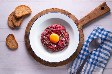 Traditional steak tartare with beef and egg yolk.