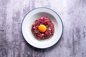 Traditional steak tartare with beef and egg yolk.