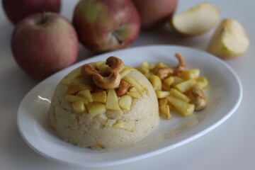 Apple Sheera. Indian pudding made of semolina flour, ghee, milk, dates and dry fruits served with caramelised apple.