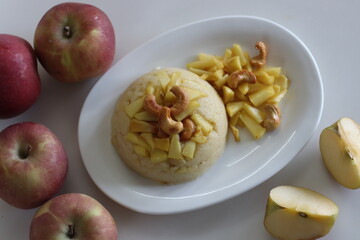 Apple Sheera. Indian pudding made of semolina flour, ghee, milk, dates and dry fruits served with caramelised apple.