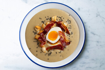 Smoked aubergine cream with crispy Iberian ham and boiled egg.