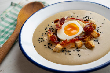 Smoked aubergine cream with crispy Iberian ham and boiled egg.