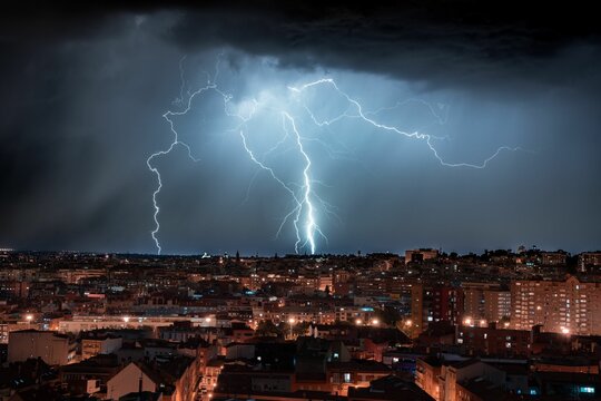 Fototapeta Scenic view of lightning hitting the ground near the city of Madrid during nighttime
