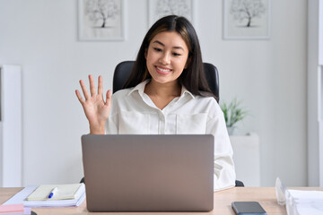 Asian business woman waving hands to greeting partner during video conference