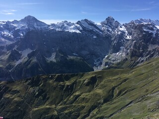 Huge mountains landscape view. Mountains in the summer sunny day in the Switzerland. Nature landscape with mountains, forest and green fields. Travel to Switzerland and mountain landscape. 