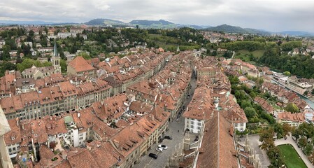 Fototapeta na wymiar Old buildings in Switzerland. Switzerland city center Bern old building made of red bricks. Building rooftop from brick. City landscape in the summer day. Europe Swiss city center. Architecture house.