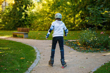 Active little boy skating in summer park, healthy lifestyle for children