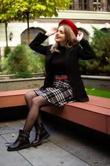 A woman in a red beret sits on a bench