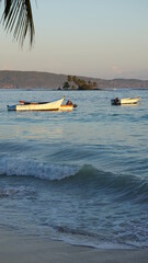 Fototapeta premium sunrise and boats on the beach Playa Las Galeras in the province of the Samana Peninsula in the Dominican Republic in the month of January 2022