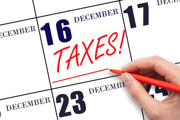 Hand drawing red line and writing the text Taxes on calendar date December 16. Remind date of tax payment