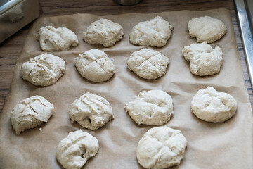 Fototapeta na wymiar Dough blanks for delicious rolls on baking paper