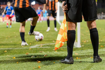 Footballer takes the corner. Detail of referee's legs during soccer match.
