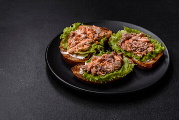 Delicious fresh sandwiches with toast, canned salmon, salad and quail eggs