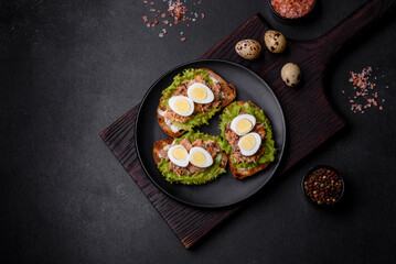 Delicious fresh sandwiches with toast, canned salmon, salad and quail eggs