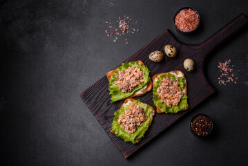 Delicious fresh sandwiches with toast, canned salmon, salad and quail eggs